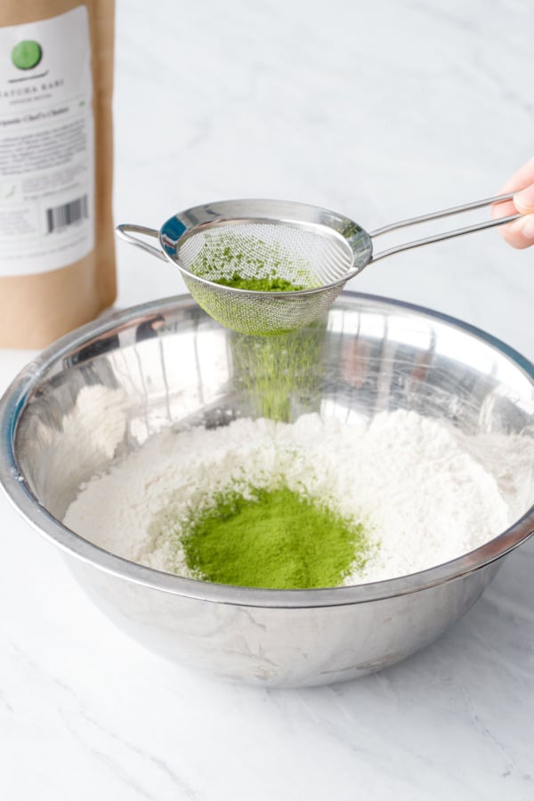 Sifting the matcha powder into a bowl of flour.