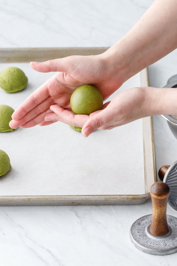 Rolling the matcha sugar cookie dough into a smooth ball.
