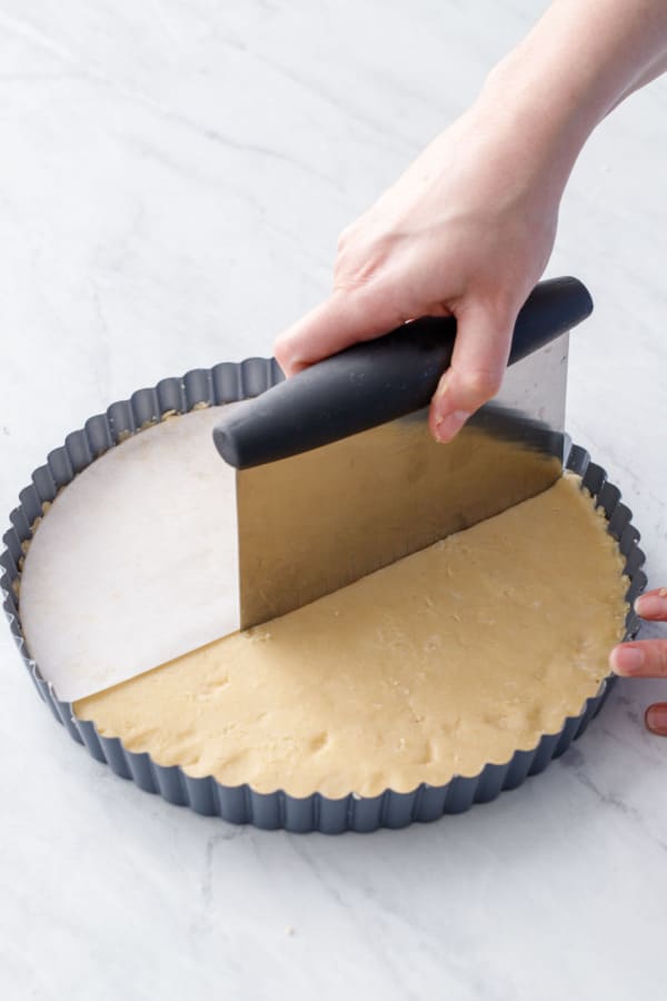 Half circle of parchment used as a guide to score dividing lines into the top of the shortbread dough with a bench scraper.