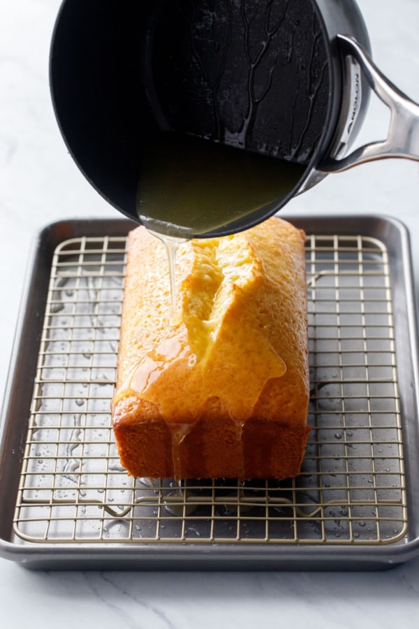 Pouring the lemon sugar syrup over the warm cake.