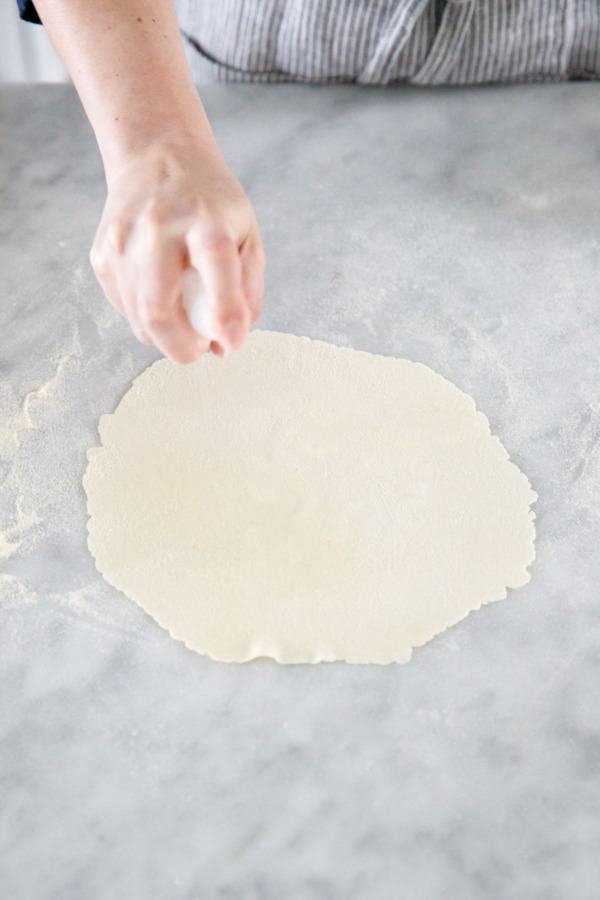Spritzing the thin rolled dough with salt water before baking