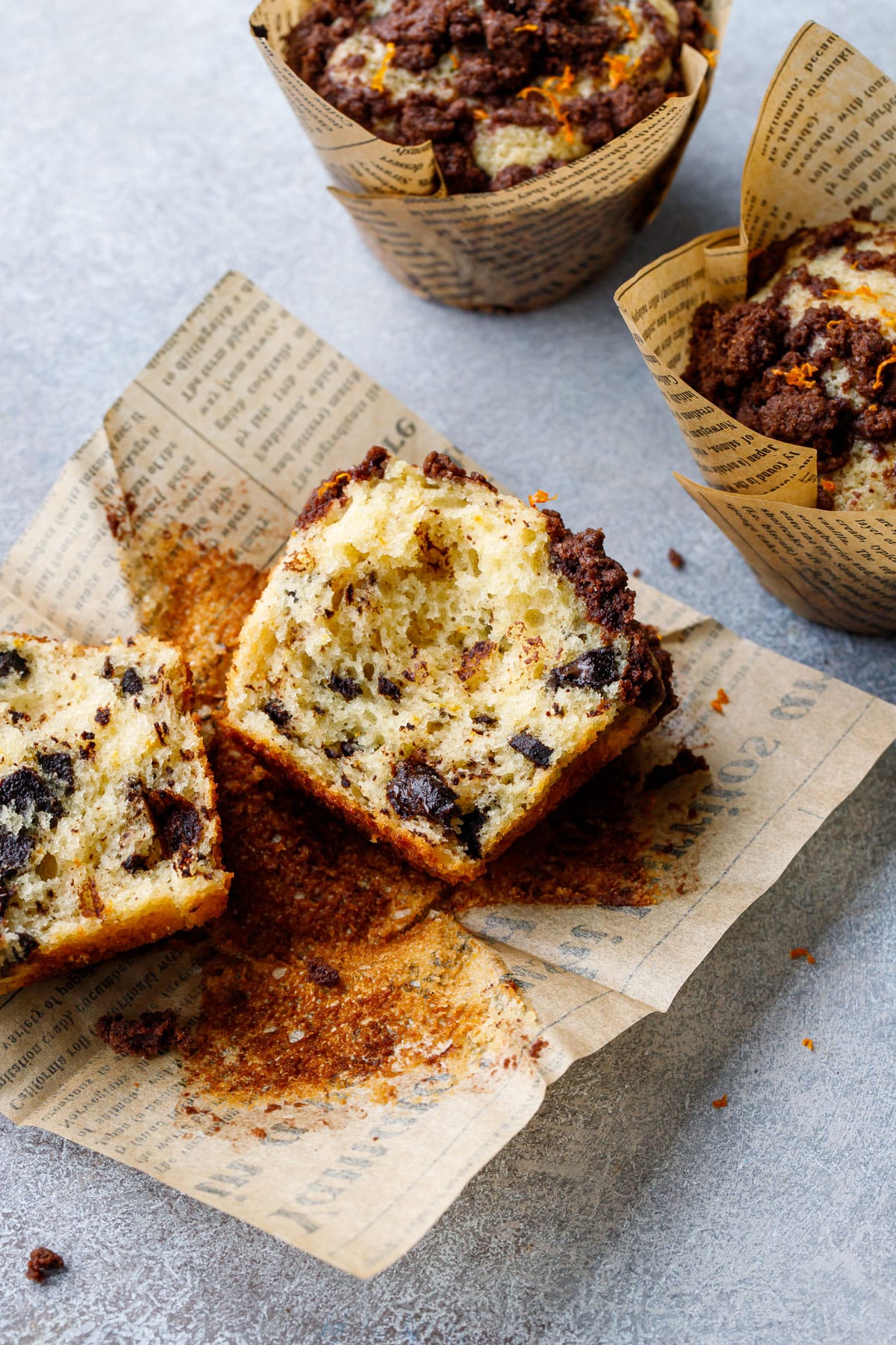 Chocolate Orange Streusel Muffin broken in half to show the tender texture and chocolate chunks inside.