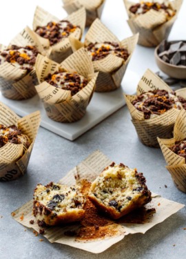 Chocolate Orange Streusel Muffins on a gray background, one muffin broken in half to show the fluffy interior texture.