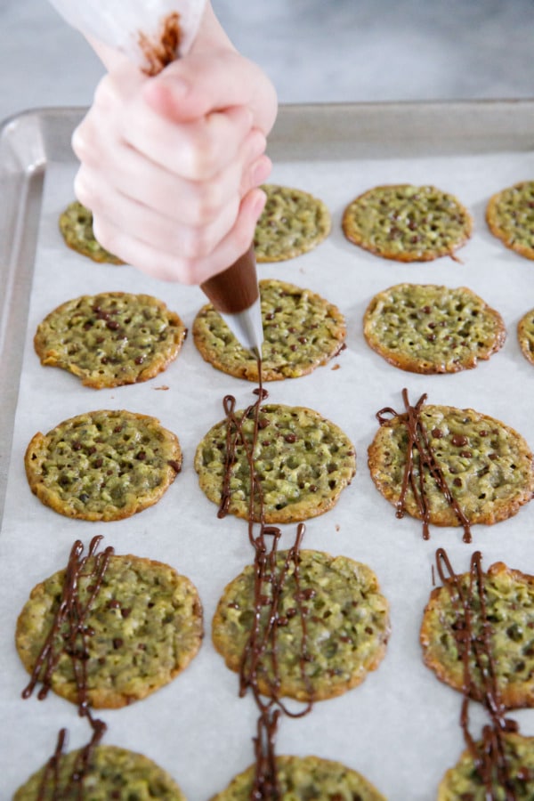 Drizzle decorative lines of dark chocolate onto tops of cooled cookies.