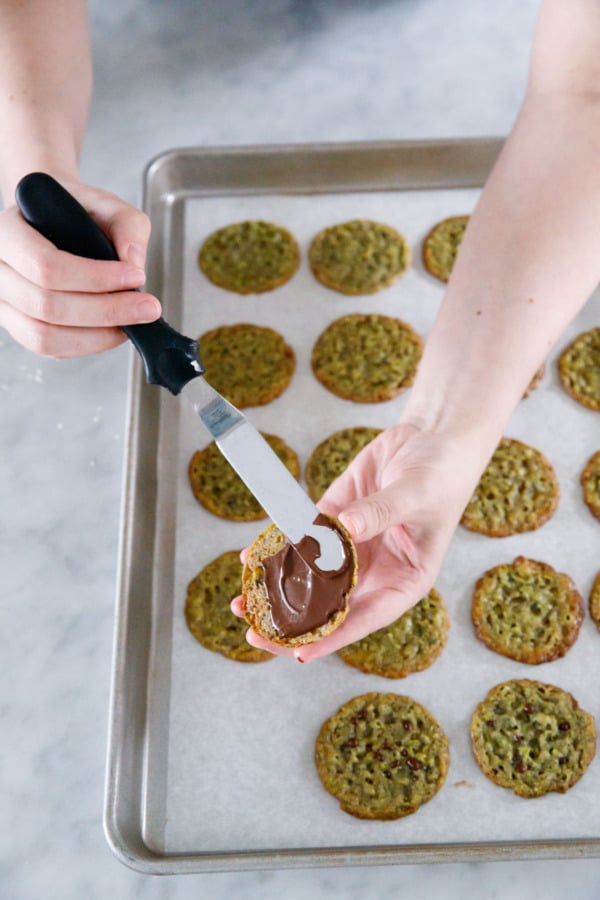 Spread a thin layer of dark or white chocolate onto the bottoms of the cooled cookies with an offset spatula.