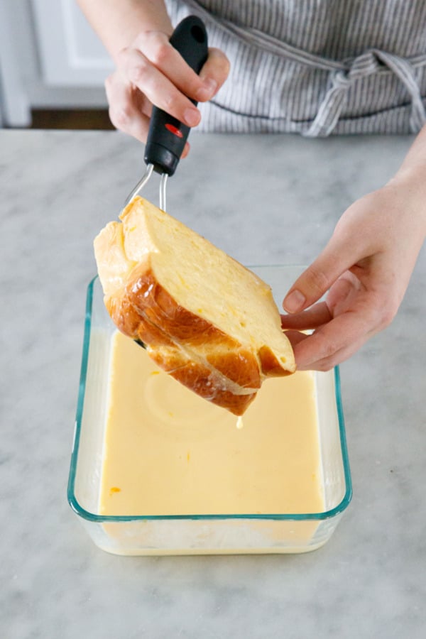Flipping the French toast to coat the other side with custard.