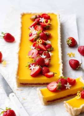 Strawberry Meyer Lemon Tart cut in slices to show the layer of strawberry jam at the bottom.