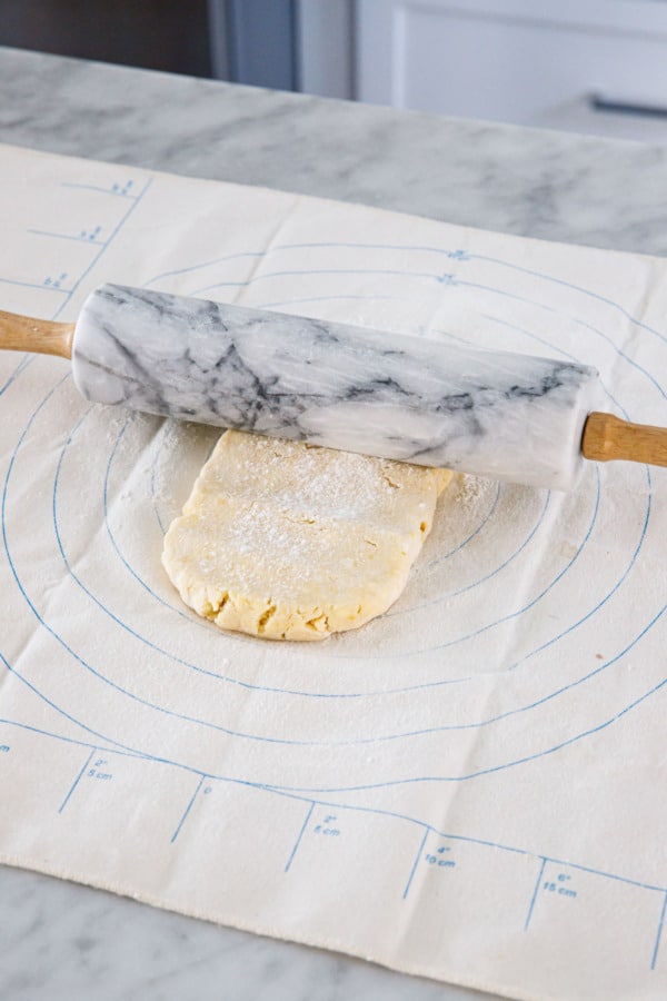 Rolling pie dough into a rectangular shape.