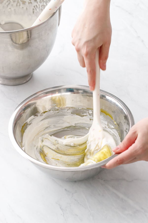 Folding in the first addition of whipped cream to lighten the pistachio mixture.