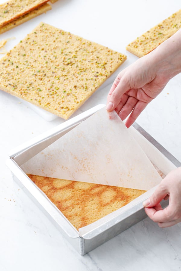 Peeling the parchment off the bottom layer of blondie.