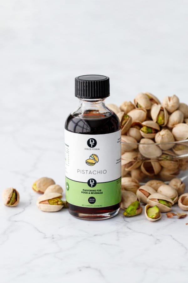 Dolce Foglia Pistachio Extract bottle with bowl of pistachios.