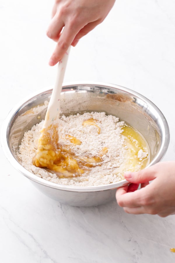 In a metal mixing bowl, stirring the wet ingredients into the dry with a silicone spatula.