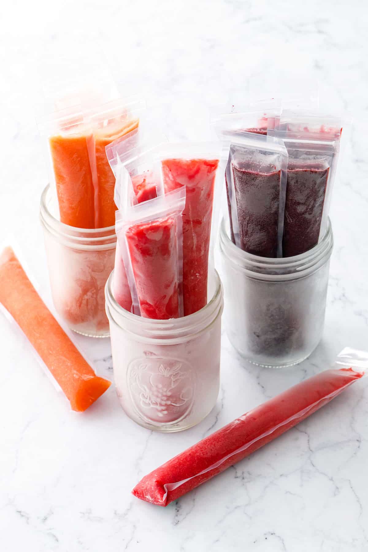 Three jars with different flavors of Freezer Jam Ice Pops: Peach, Strawberry, and Blueberry