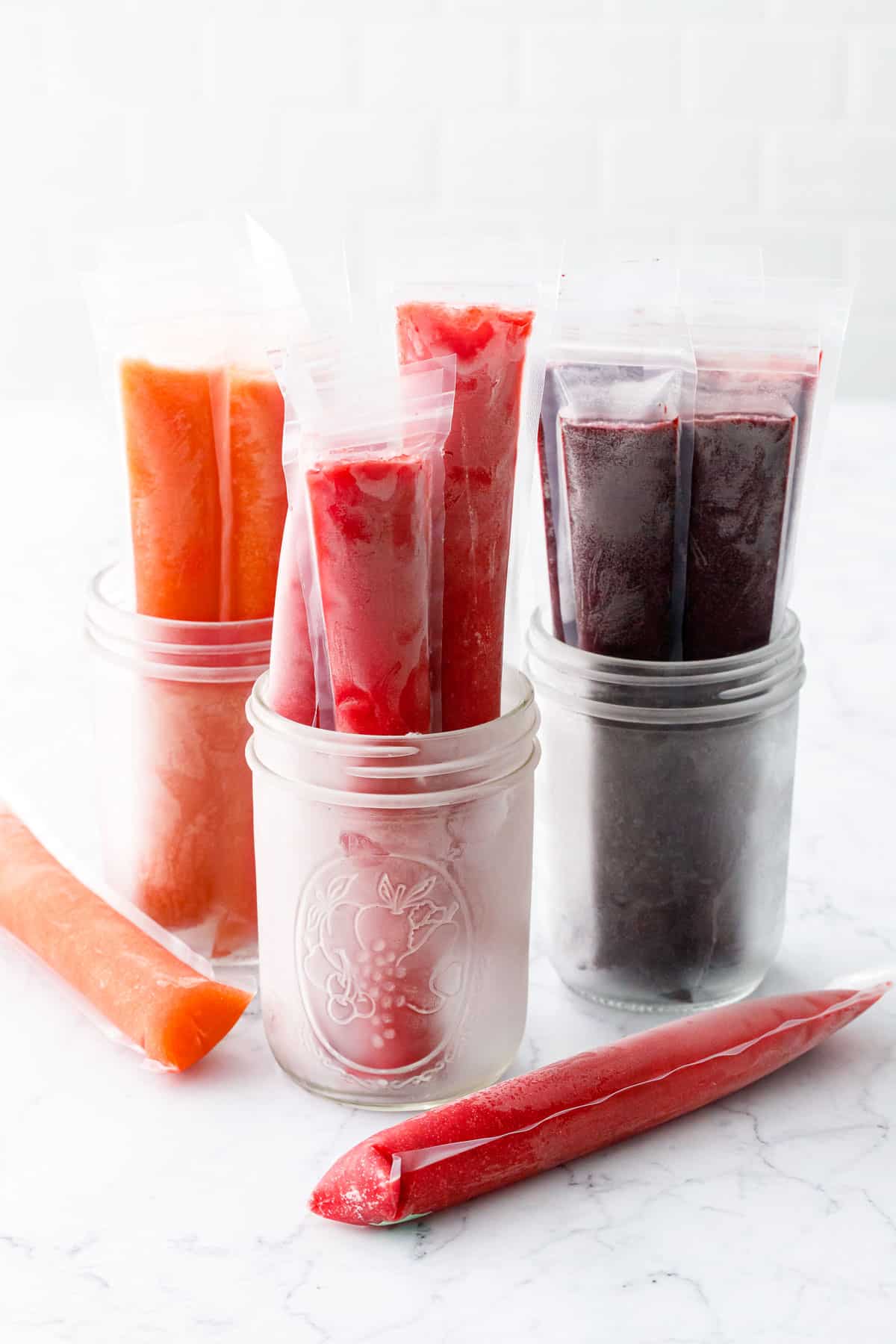 Three jars with different flavors of Freezer Jam Ice Pops: Peach, Strawberry, and Blueberry