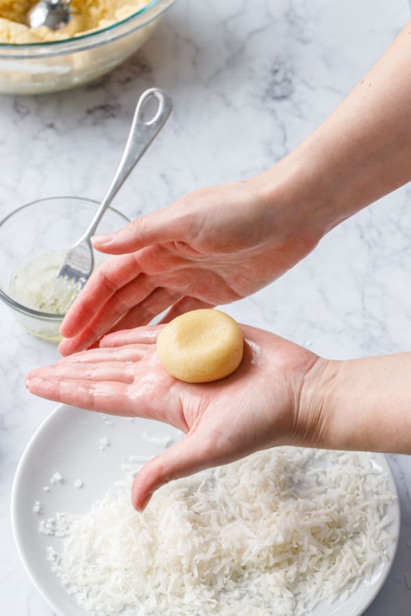 Rolling balls of dough into a slightly flattened circle between your palms.