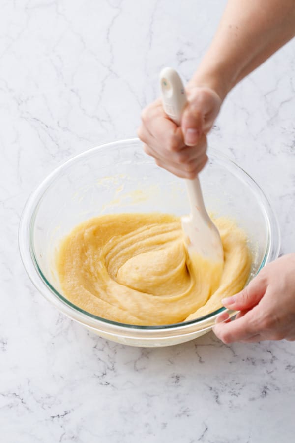 Mixing in eggs with other ingredients until the batter is smooth.