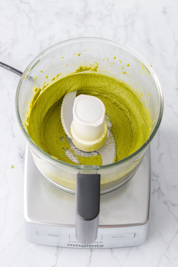 Continuing to process the pistachios in the food processor will make the pistachio butter thinner and smoother.