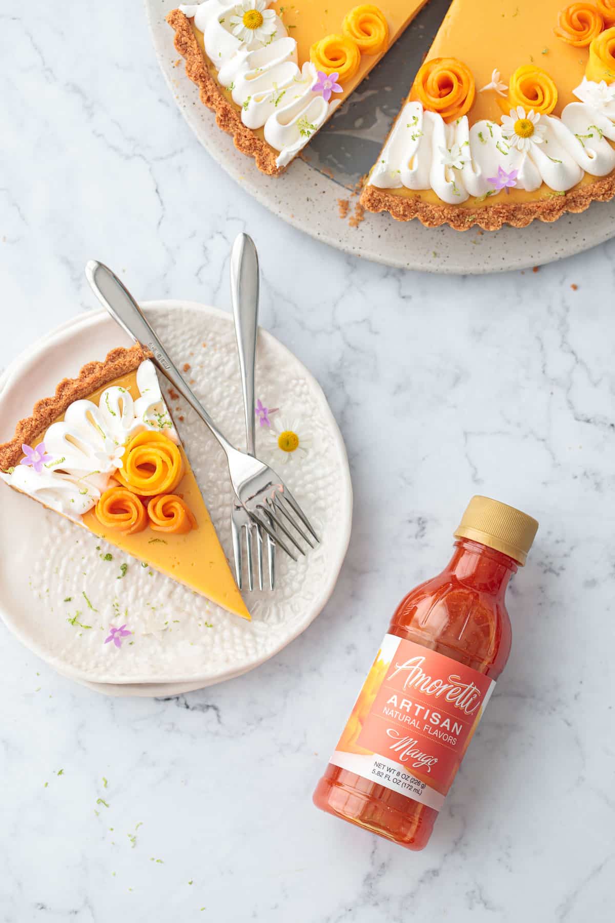 Overhead, plate with slice of Mango Lime Tart and a bottle of Amoretti Natural Artisan Mango Flavor on the side.