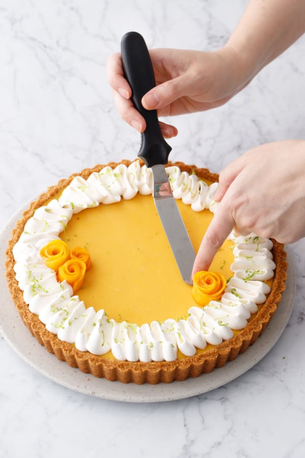 Arranging mango flowers on top of the baked and chilled tart before serving.