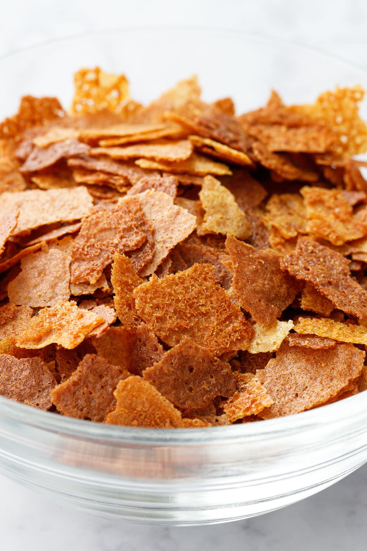 Closeup shot showing the light and crispy texture of a bowl of Homemade Feuilletine flakes.