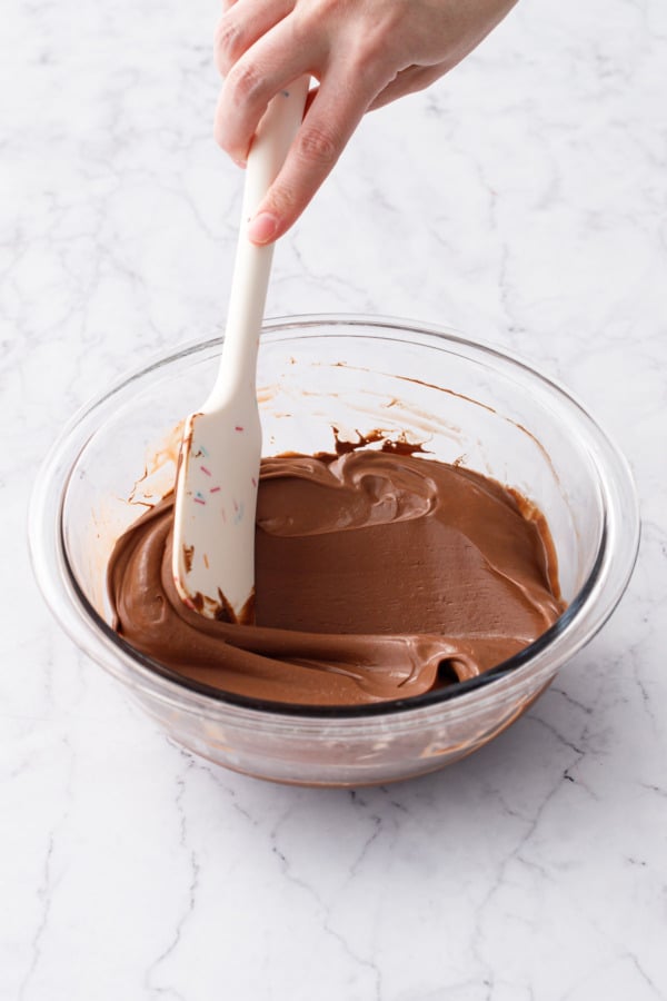 Spatula running through the chilled chocolate filling mixture to show the thick consistency.