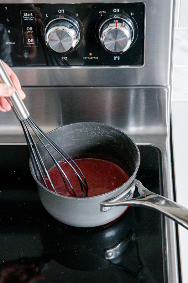 Whisking blood orange juice and powdered sugar over low heat until dissolved.