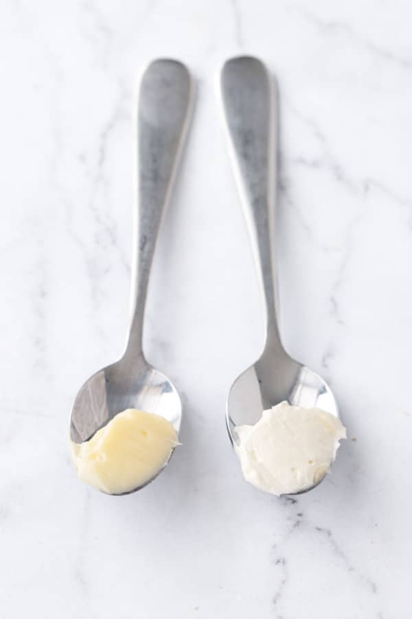 Two spoons showing softened butter on the left and fully creamed butter on the right, which is noticeably lighter in color.