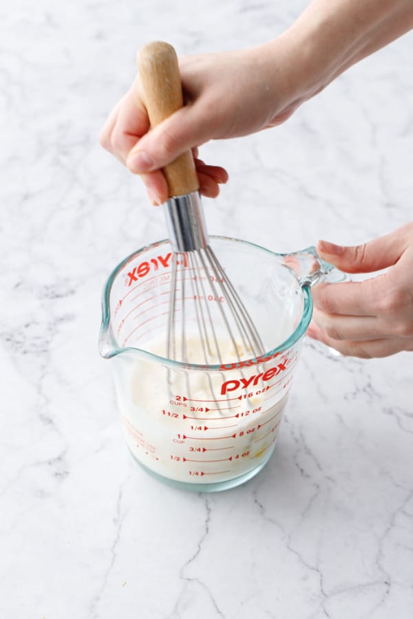 Whisking egg with milk and a 2 cup pyrex glass measuring cup.