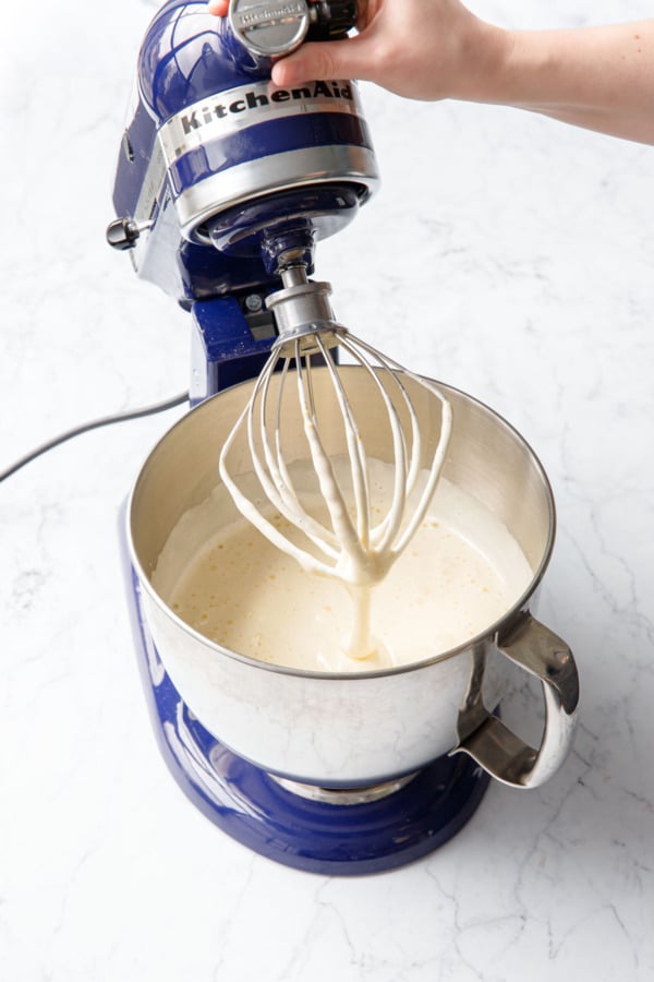 Using a butter wrapper to grease the inside of a 9-inch aluminum cake pan with removable bottom.