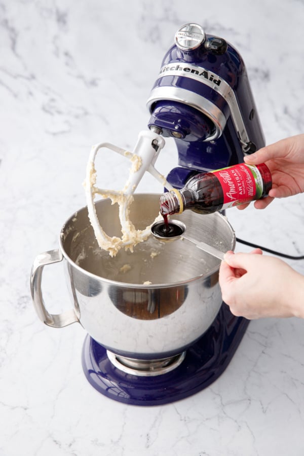 Measuring Amoretti Wild Strawberry Artisan Flavoring in a tablespoon measuring spoon.