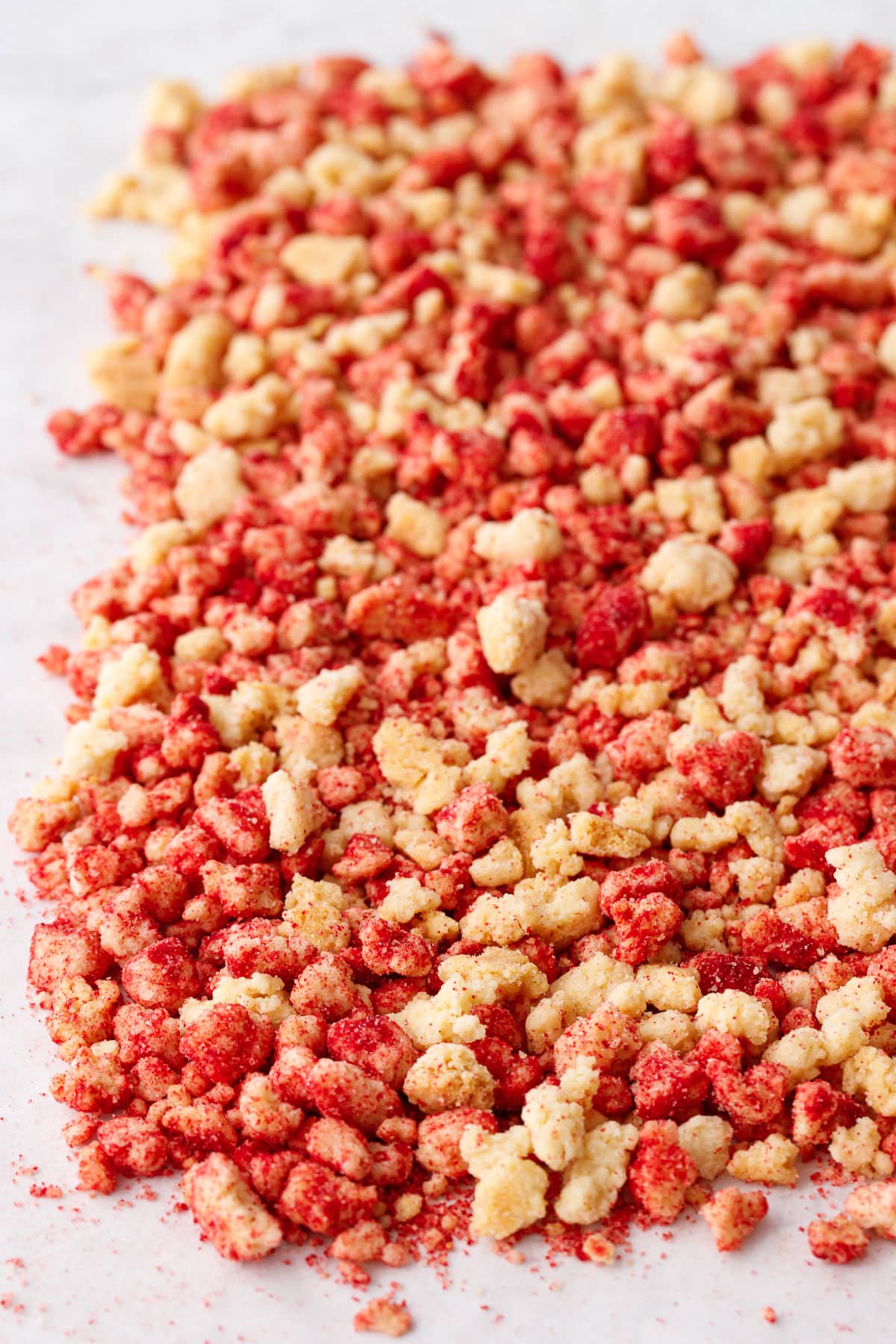 Closeup of Strawberry Shortcake Crunch Topping showing the two colors of crumbs on a marble background.