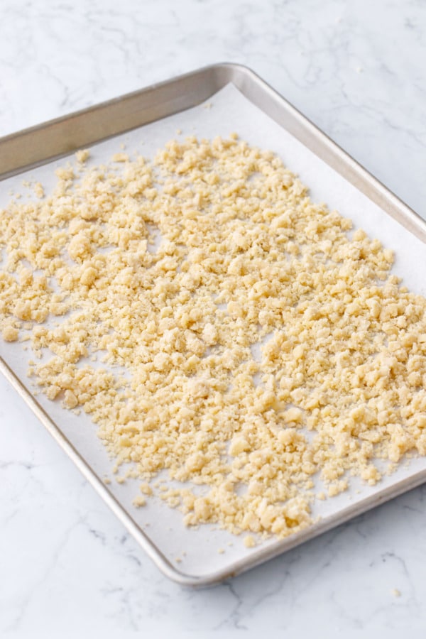 Spread crumbles out on an even layer on parchment-lined cookie sheet.