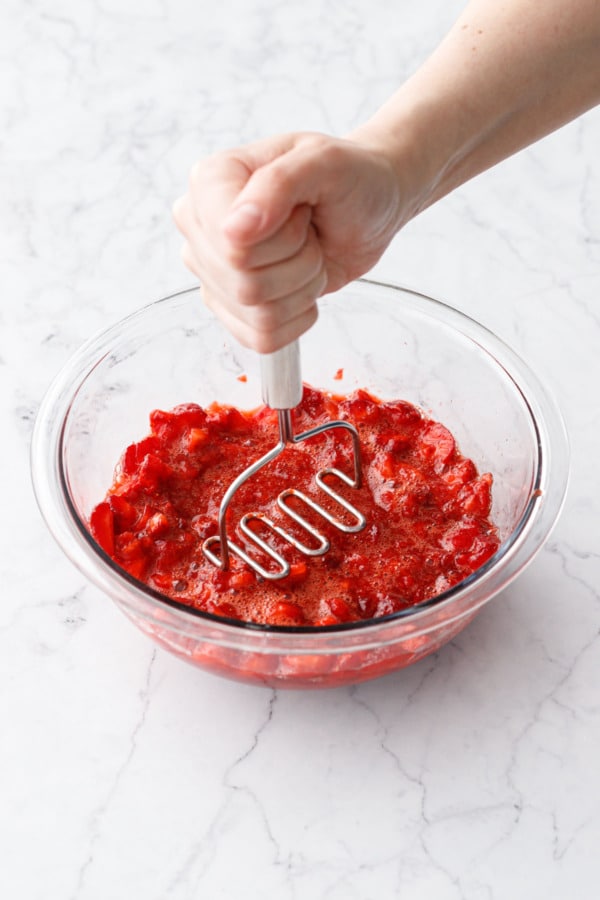 Mashing chopped ripe strawberries with a potato masher, they will look looser and juicer as you go.