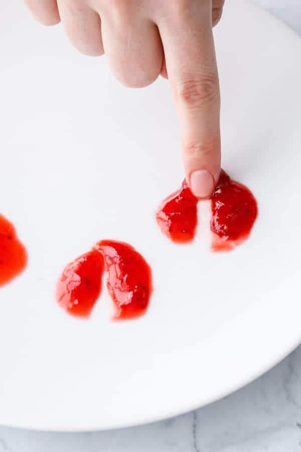 Finger swiping through a chilled dollop of jam; if properly set the jam will leave a visible track and not fill back in.