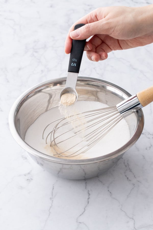 Adding Pomona's pectin to a bowl with granulated sugar.