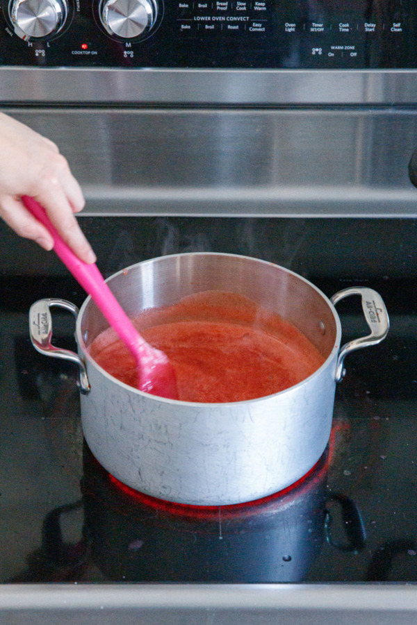 Stirring hot fruit mixture until pectin is dissolved and mixture returns to a full boil.