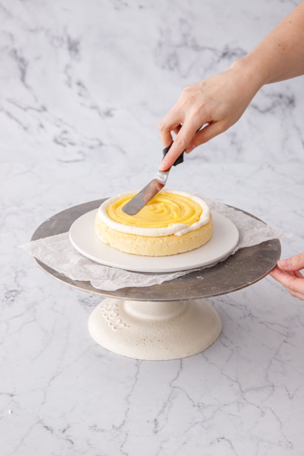 Spreading lemon curd into an even layer with an offset spatula.