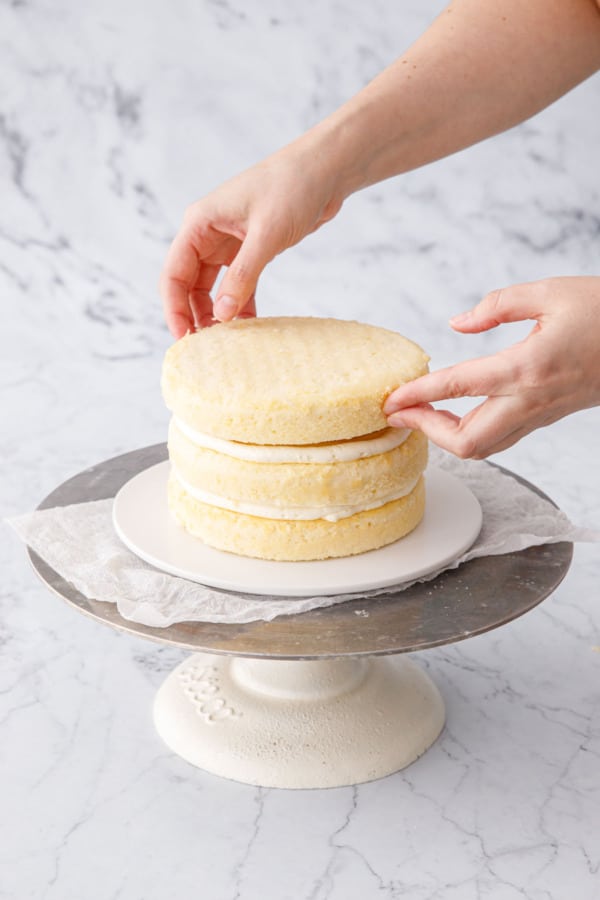 Adding the top (third) layer of the Triple Lemon Layer Cake.
