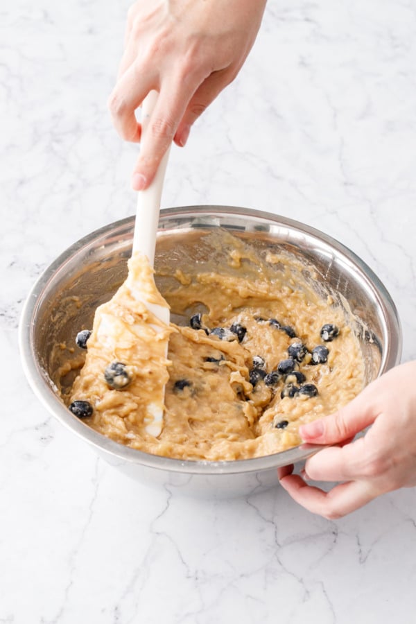 Folding blueberries into the banana bread batter.