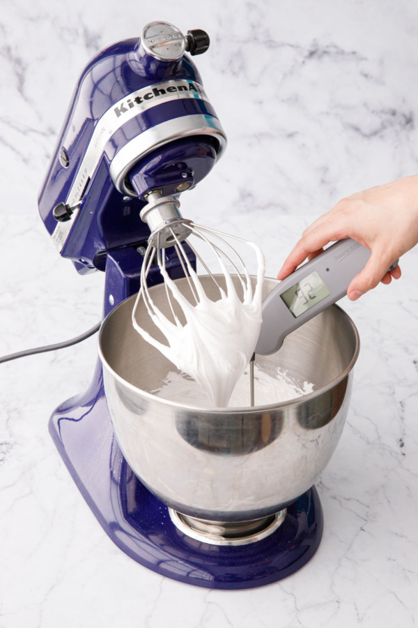Checking the temperature of the whipped meringue with a digital thermometer.