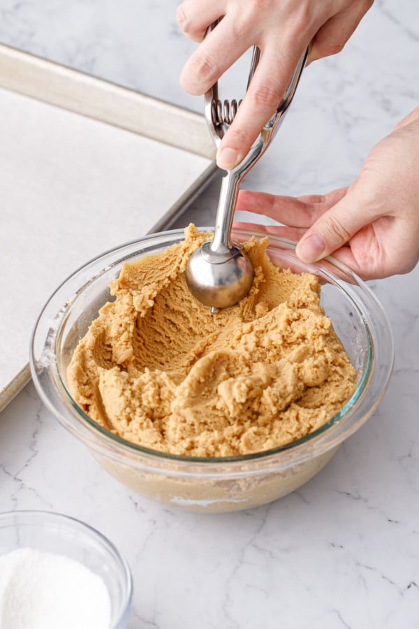 Bowl of peanut butter thumbprint cookie dough in a glass bowl.