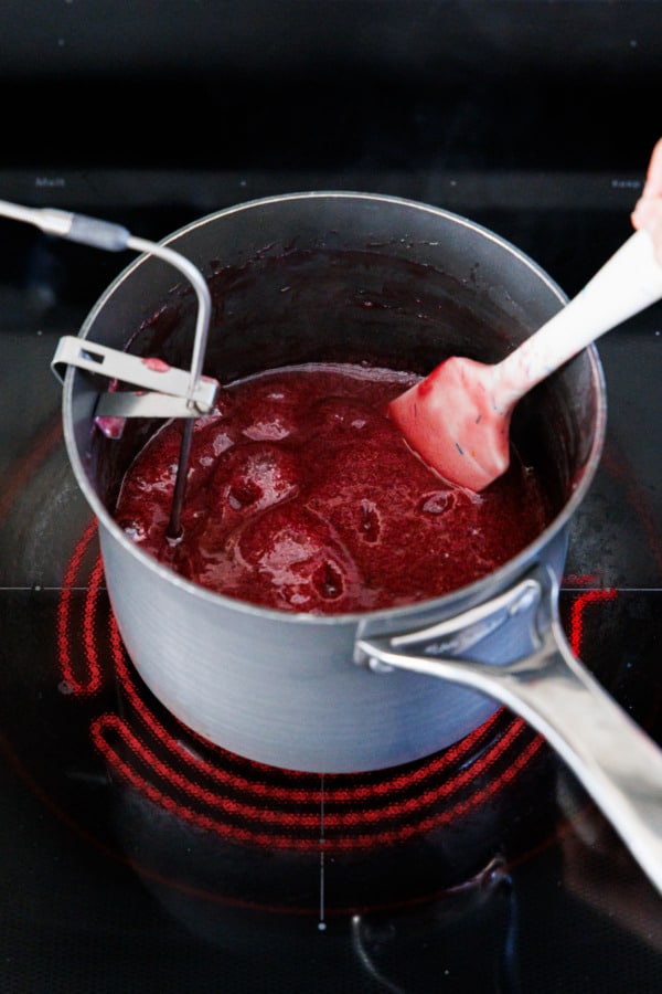Almost cooked raspberry gummy candy mixture, has noticeably thickened and reduced in volume.