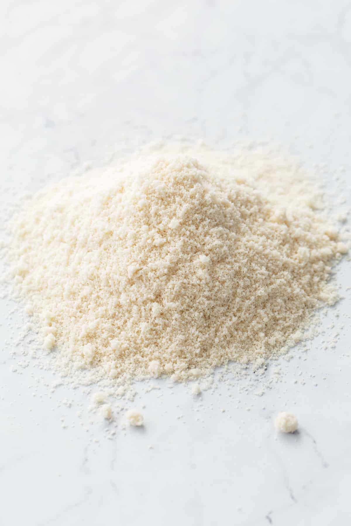 Pile of Homemade Blanched Almond Flour on a marble countertop.