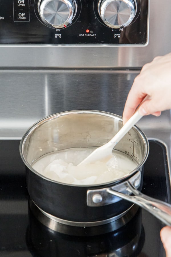 Combining sugar, corn syrup, and water in a small stainless saucepan.
