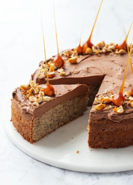 Flourless Hazelnut Cake with Nutella Whipped Ganache with one slice cut out to show the layers.
