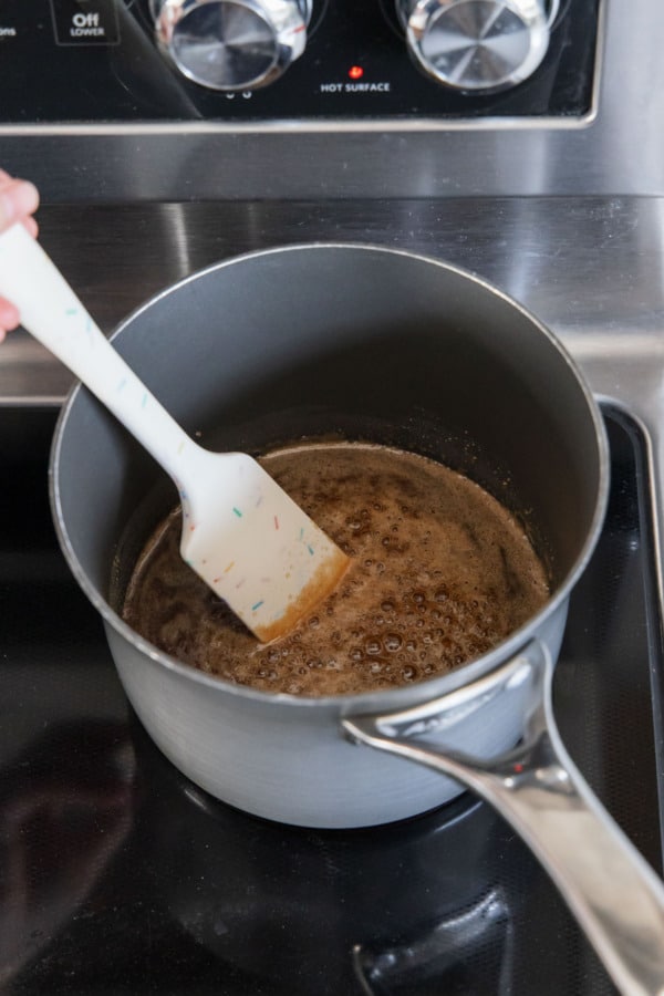 Brining the brown sugar, corn syrup, and maple syrup to a boil.