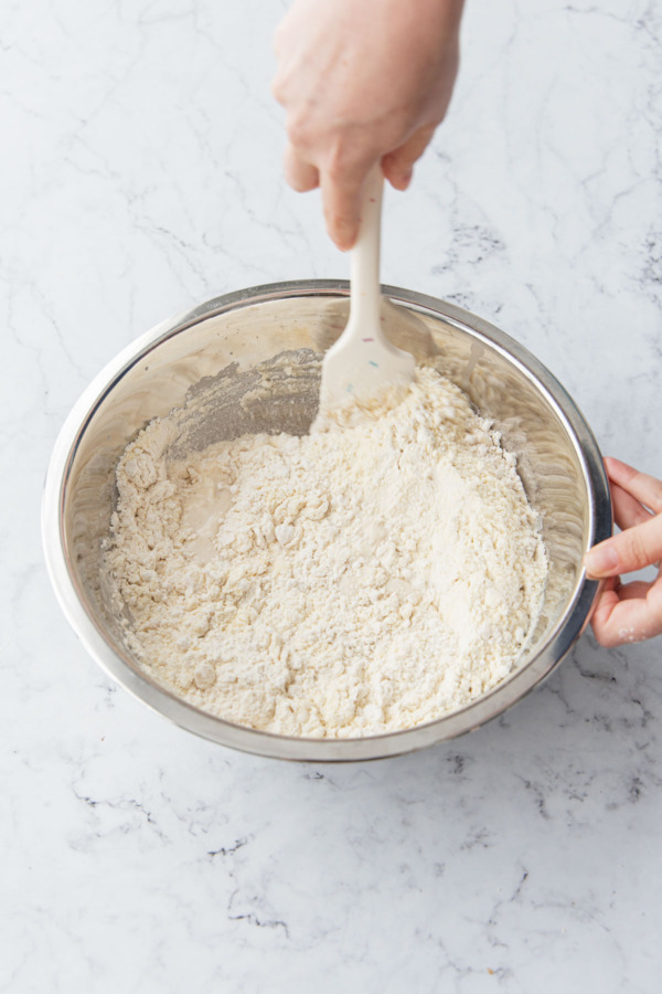 Mixing the focaccia dough to incorporate the flour.