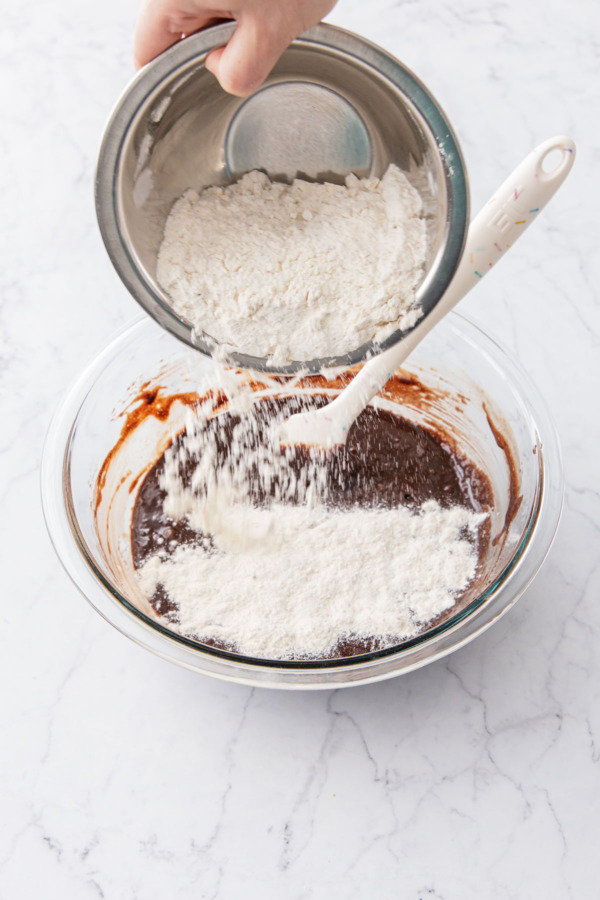 Adding dry ingredients to mixing bowl (flour, baking powder, salt, and espresso powder).