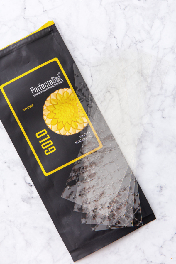 Package of Gold strength sheet gelatin on a white marble background.