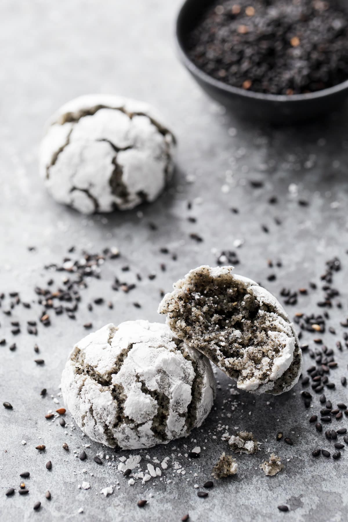 Closeup, Black Sesame Amaretti Cookies with one bite taken out of one cookie to show the interior texture.